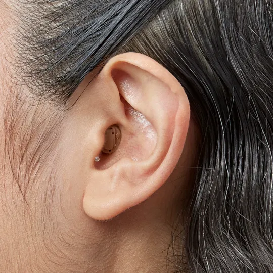 Completely in the canal hearing aid shown worn in the ear